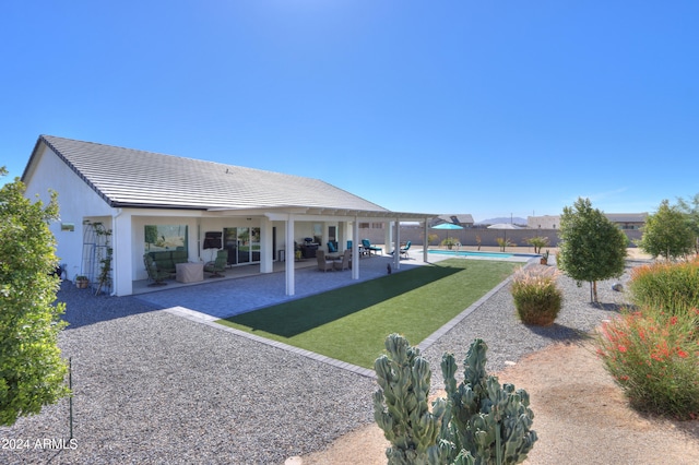 back of property with a patio area, a lawn, and an outdoor living space