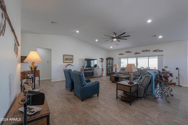 living room with ceiling fan, light wood-type flooring, and vaulted ceiling