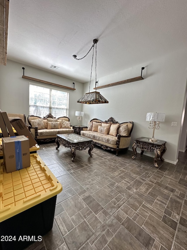 living room with a textured ceiling and dark tile floors