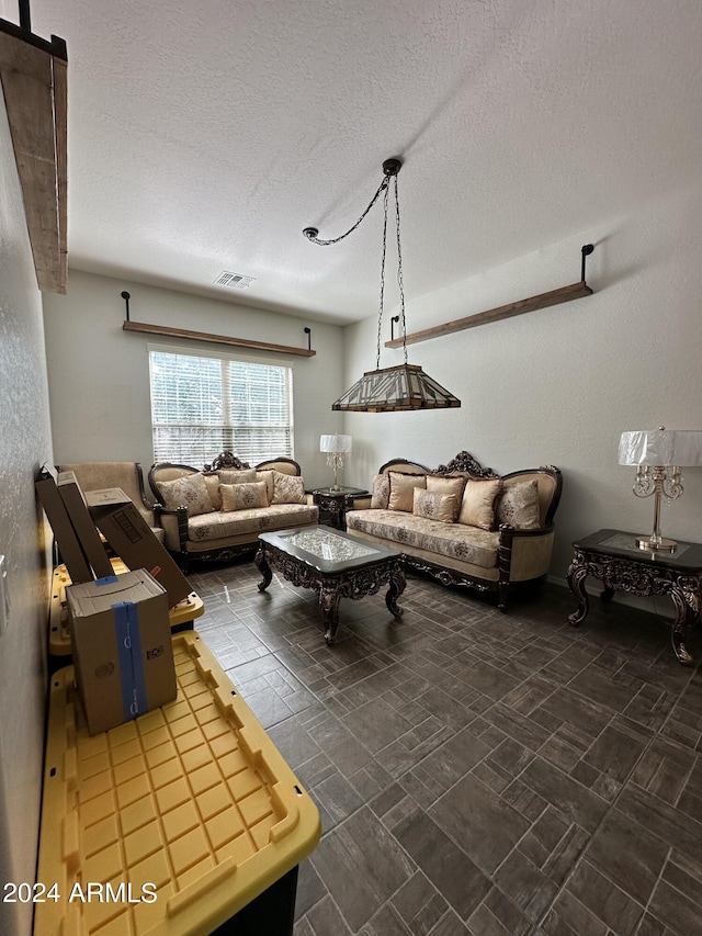 tiled living room with a barn door and a textured ceiling