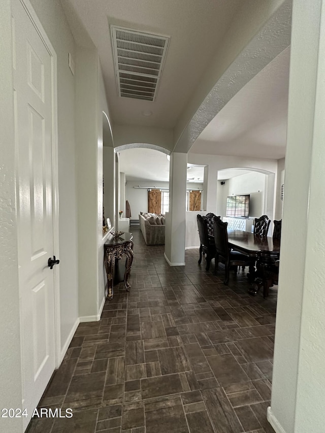 hallway featuring dark tile flooring