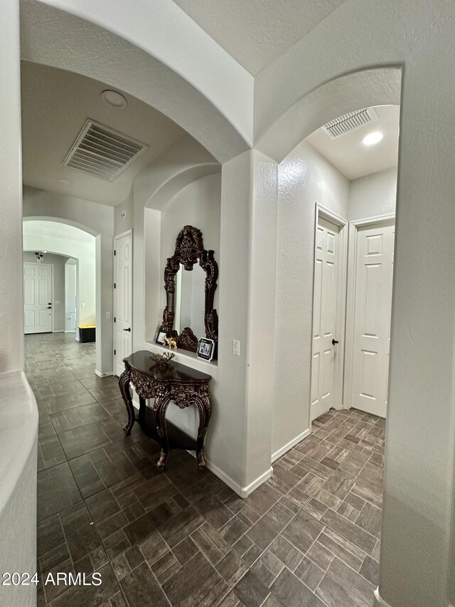 hall with dark tile floors