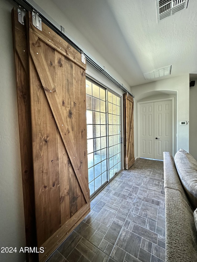 doorway with a textured ceiling and dark tile floors