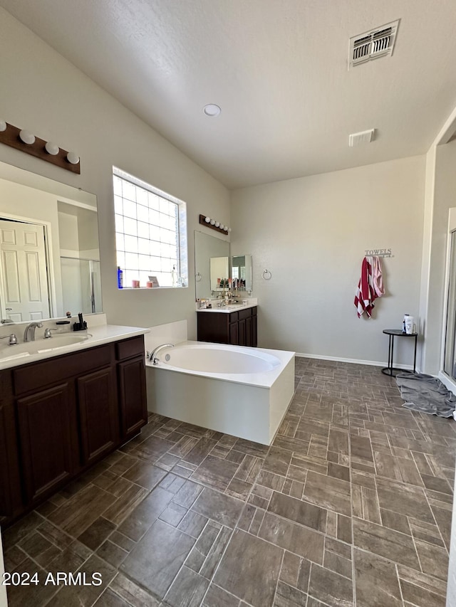 bathroom featuring a washtub, tile floors, and large vanity