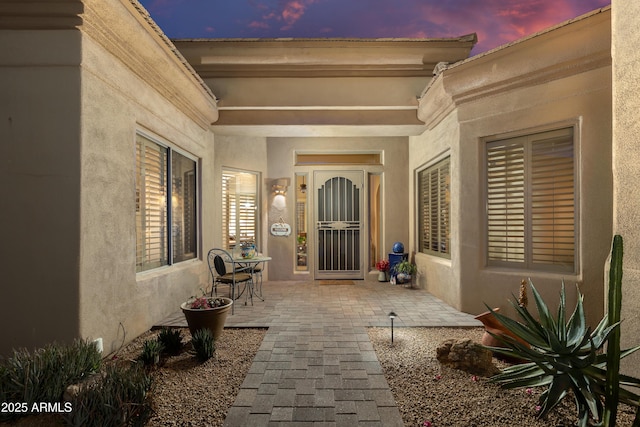 exterior entry at dusk with a patio area