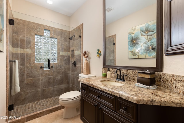 bathroom featuring vanity, a shower with shower door, and toilet