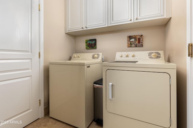 laundry area featuring washing machine and dryer and cabinets