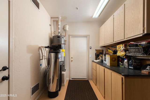 kitchen with gas water heater and light brown cabinets