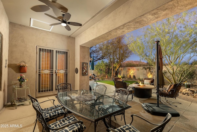 view of patio featuring ceiling fan and a fire pit