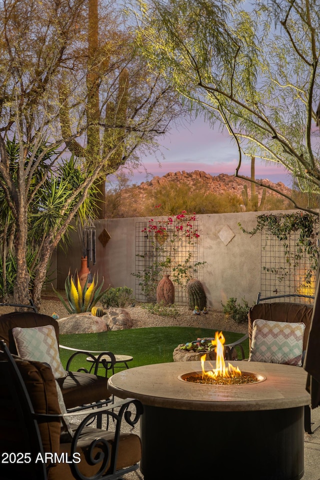 patio terrace at dusk featuring an outdoor fire pit