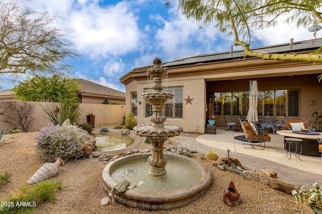 rear view of property with a patio area and a fire pit