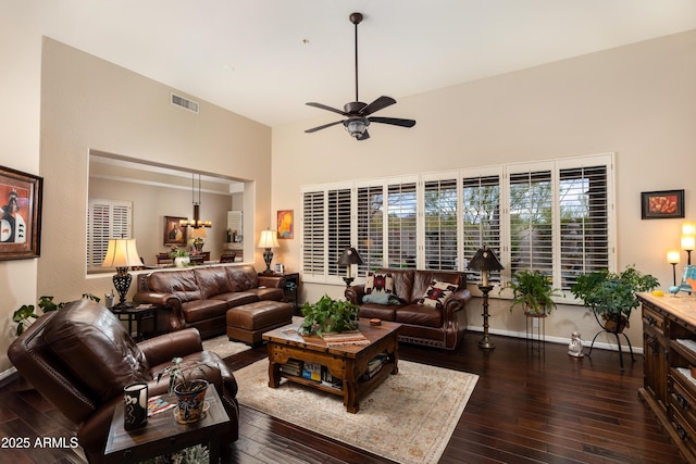 living room featuring ceiling fan, a towering ceiling, and dark hardwood / wood-style flooring