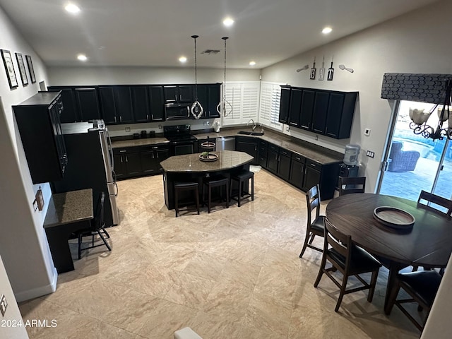 kitchen with hanging light fixtures, sink, a kitchen island, stainless steel appliances, and a breakfast bar area