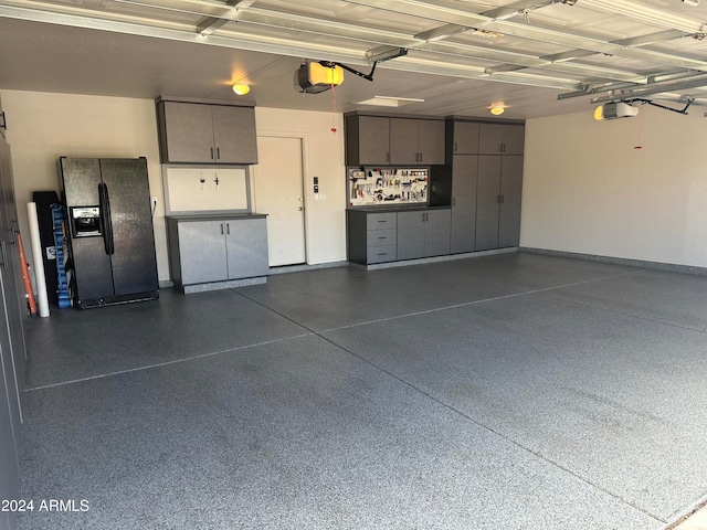 garage featuring a garage door opener and black fridge