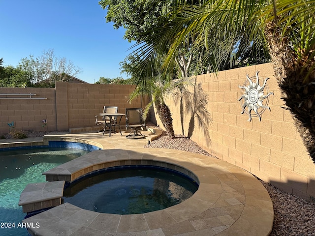 view of pool featuring an in ground hot tub