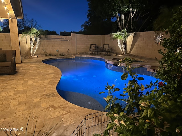 pool at twilight featuring a patio