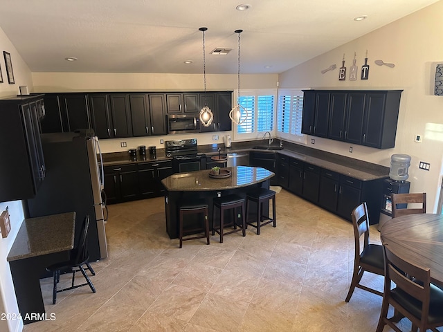 kitchen featuring a center island, sink, hanging light fixtures, a breakfast bar area, and appliances with stainless steel finishes