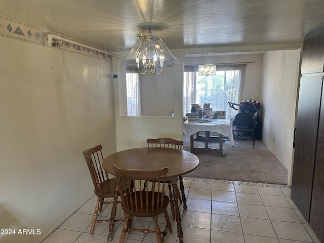 dining room with light tile patterned floors, plenty of natural light, and an inviting chandelier