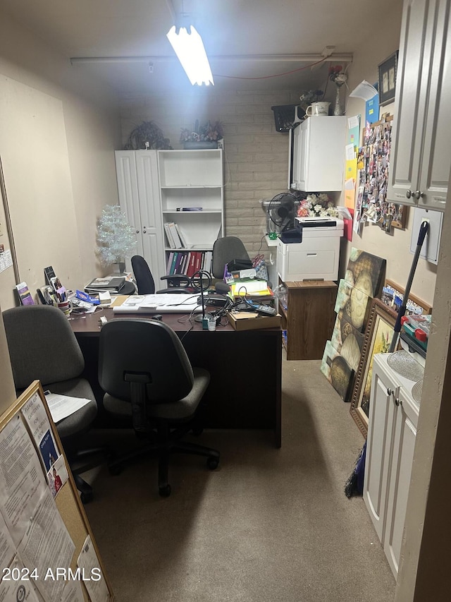 office with carpet floors and brick wall