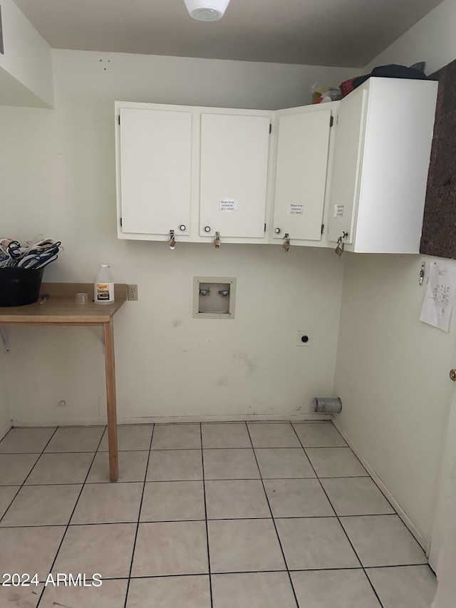 laundry room featuring light tile patterned flooring, washer hookup, hookup for an electric dryer, and cabinets