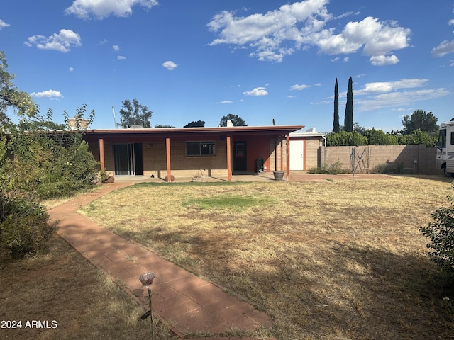 back of property featuring a patio area and a yard