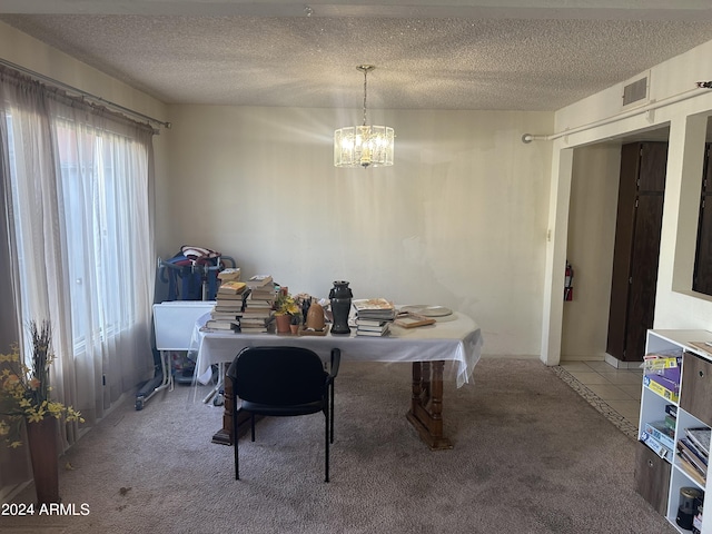 dining room featuring a textured ceiling, carpet, and a chandelier