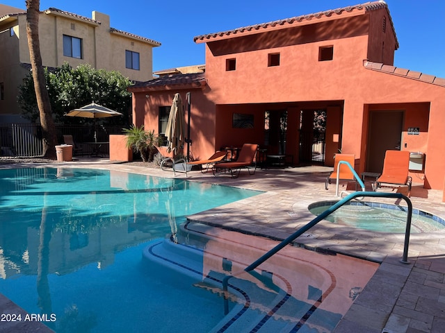 view of pool featuring a hot tub and a patio area