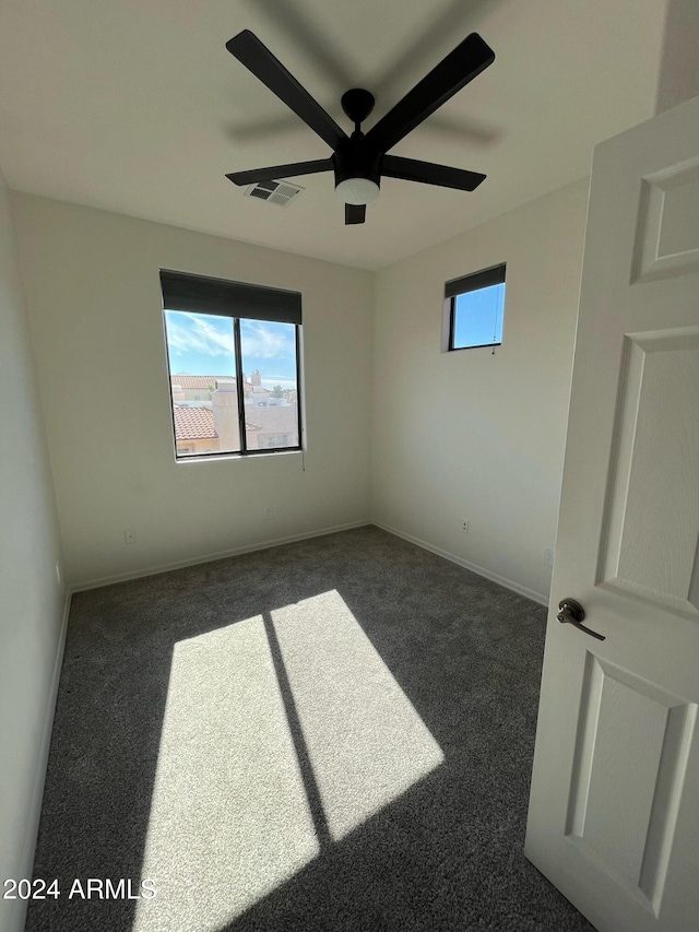 carpeted spare room featuring ceiling fan