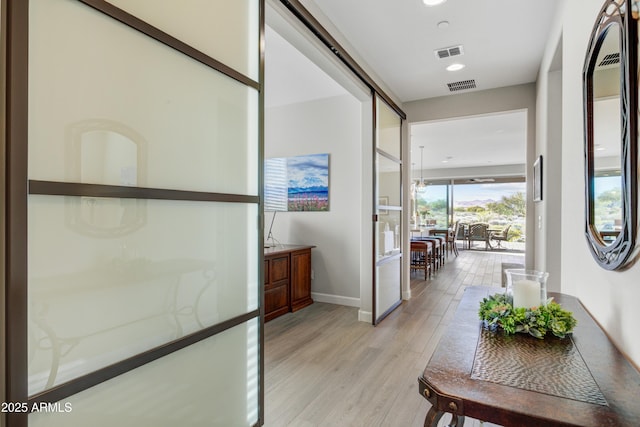 hall with light wood-style flooring, baseboards, and recessed lighting