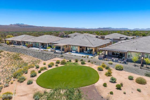 back of house featuring a patio, an outdoor living space, a residential view, and a mountain view