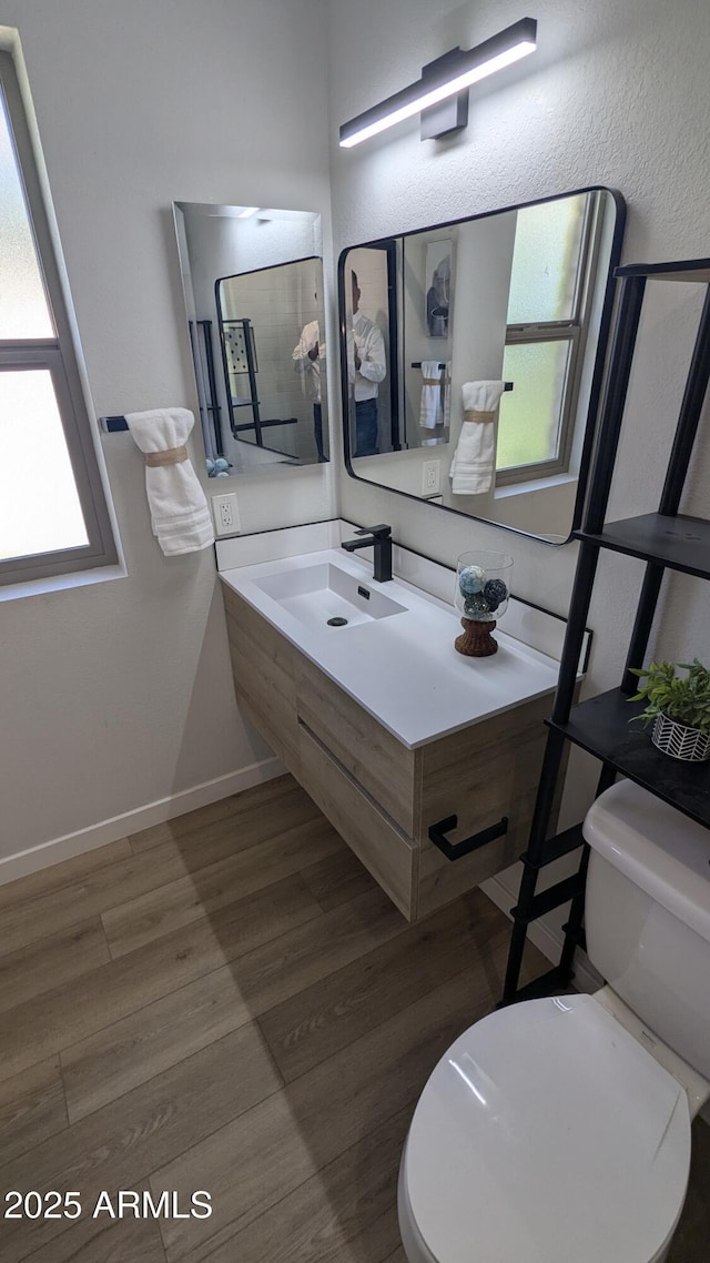4442 E Aire Libre Ave, Phoenix, AZ 85032 - bathroom with toilet, wood finished floors, vanity, and baseboards