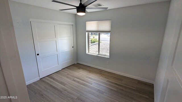 4442 E Aire Libre Ave, Phoenix, AZ 85032 - unfurnished bedroom featuring wood finished floors, a closet, baseboards, and a ceiling fan