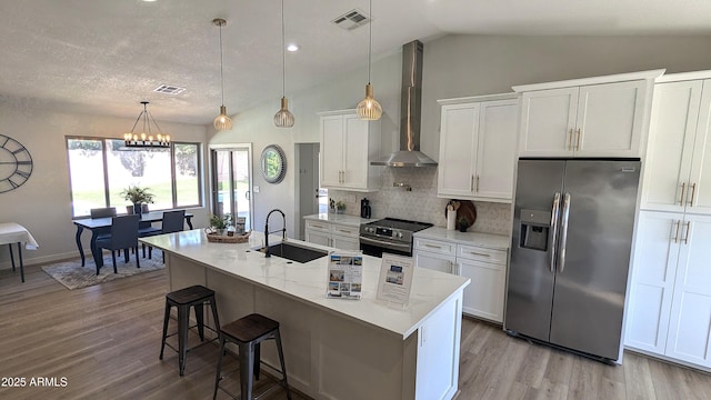 4442 E Aire Libre Ave, Phoenix, AZ 85032 - kitchen featuring stainless steel appliances, wall chimney range hood, a sink, light wood-style floors, and white cabinets