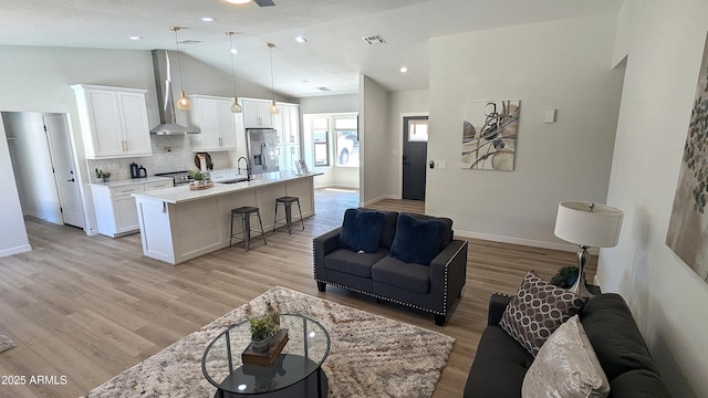 4442 E Aire Libre Ave, Phoenix, AZ 85032 - living area featuring lofted ceiling, light wood-style flooring, baseboards, and a ceiling fan