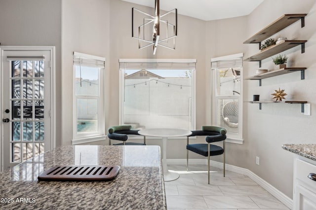 dining space with a chandelier and baseboards