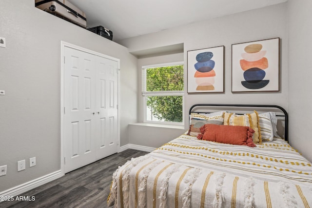 bedroom featuring a closet, dark wood-style flooring, and baseboards