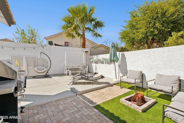 view of patio / terrace with an outdoor fire pit and a fenced backyard