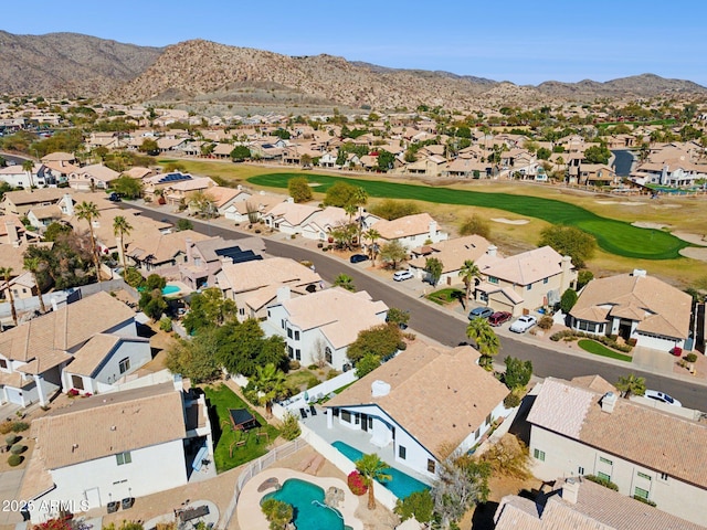 drone / aerial view with view of golf course, a residential view, and a mountain view