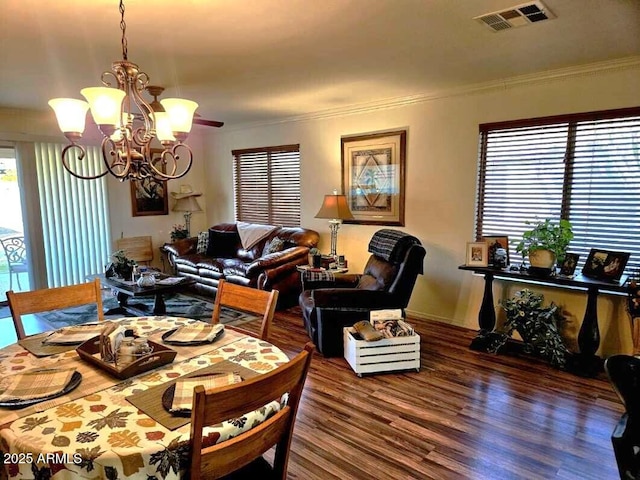 dining space featuring ornamental molding, an inviting chandelier, and dark hardwood / wood-style flooring