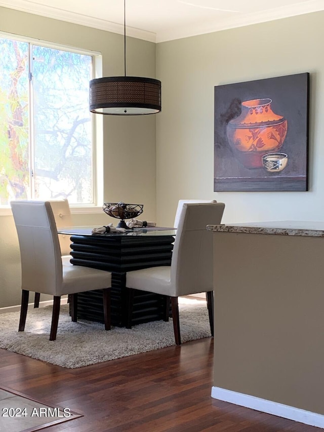 dining space featuring dark hardwood / wood-style floors, crown molding, and a wealth of natural light