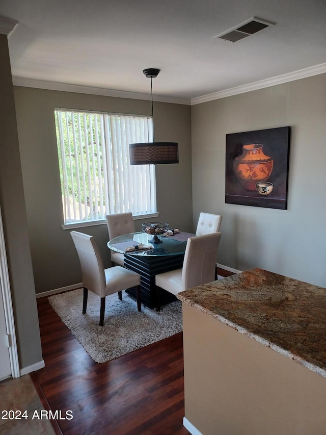 dining room featuring dark hardwood / wood-style floors and ornamental molding