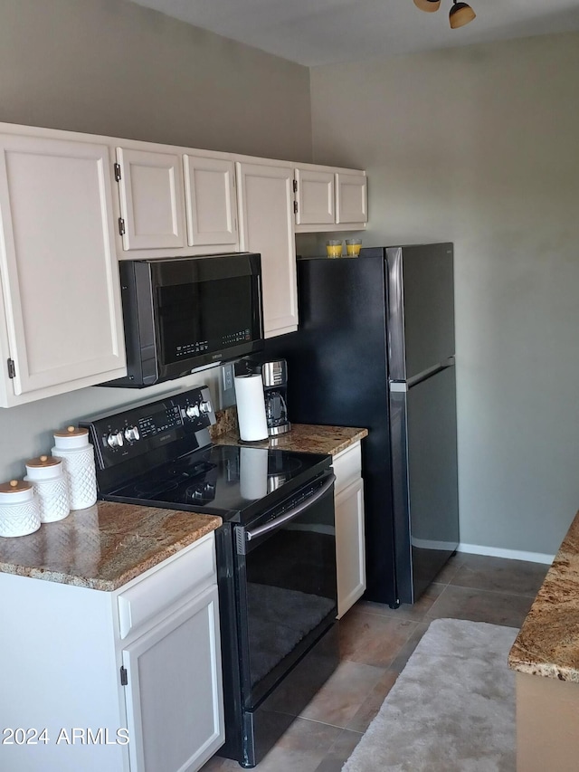 kitchen with white cabinets, dark stone countertops, and black appliances