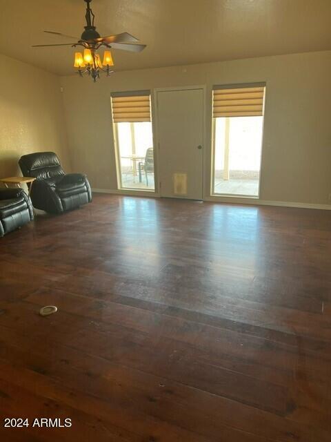 unfurnished living room featuring ceiling fan and dark hardwood / wood-style flooring