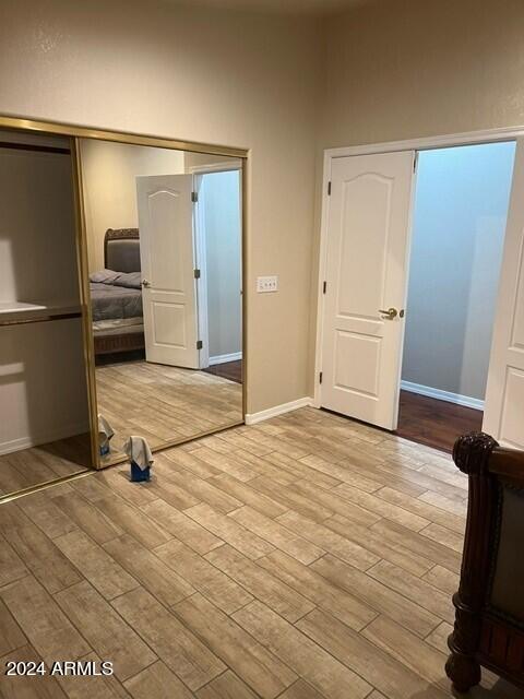 unfurnished bedroom featuring light wood-type flooring and a closet