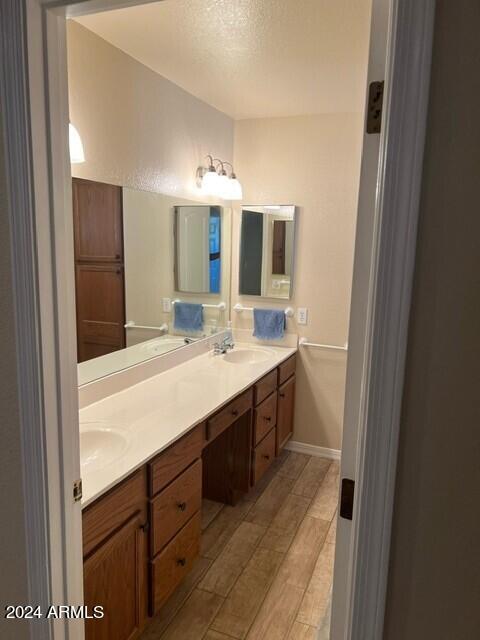 bathroom featuring vanity, hardwood / wood-style flooring, and a textured ceiling