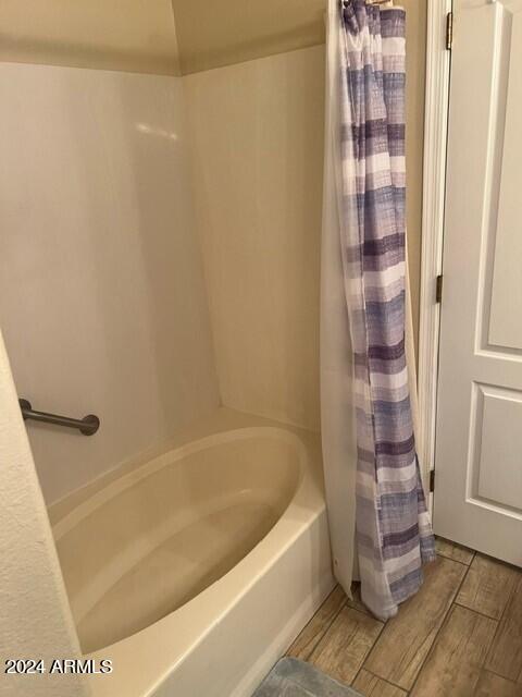 bathroom with shower / bath combination with curtain and hardwood / wood-style flooring