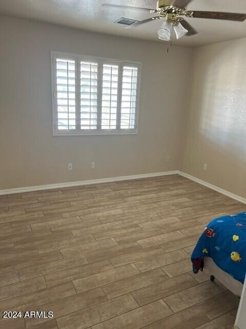 unfurnished bedroom with ceiling fan and light wood-type flooring