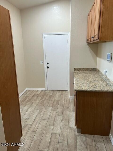 kitchen featuring light stone countertops and light wood-type flooring