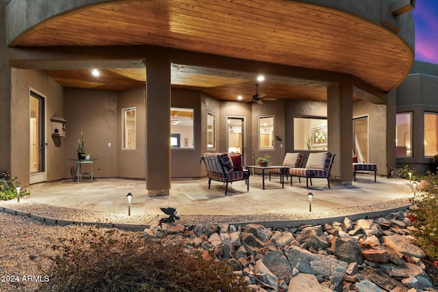 back house at dusk with an outdoor living space, a patio, and ceiling fan