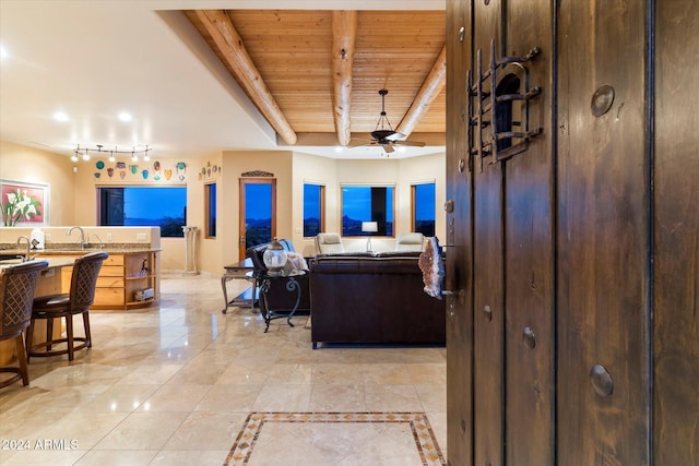 living room with ceiling fan, beam ceiling, wooden ceiling, and sink